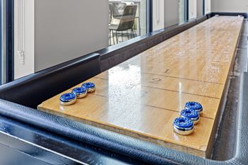 A shiny wooden table with blue buttons on it.